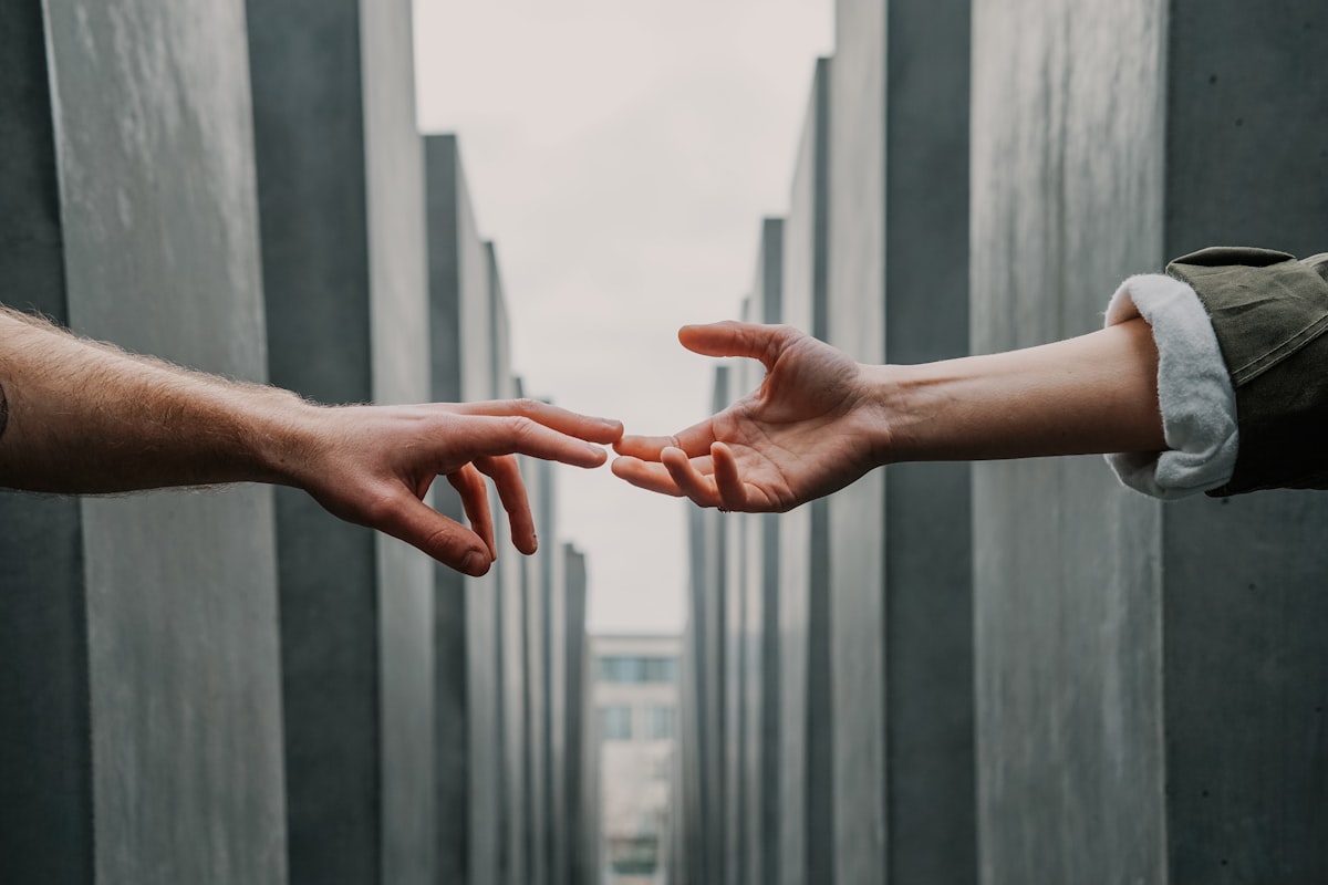 Two hands reaching toward one another, a symbol of support and partnership